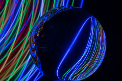 Close-up of multi colored light painting against black background