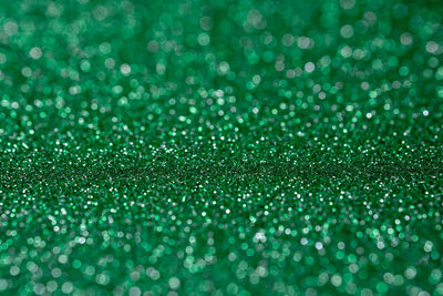 Full frame shot of green glitters on road