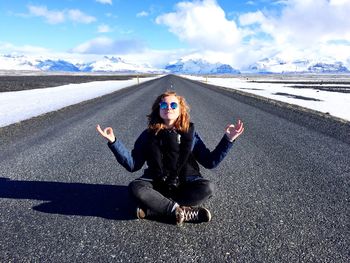 Full length of woman sitting on road