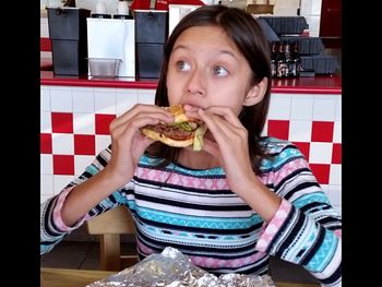 Portrait of young woman eating at home