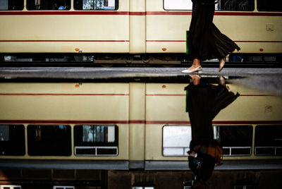 Low section of woman walking by tram in city