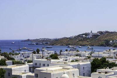 Buildings by sea against clear sky
