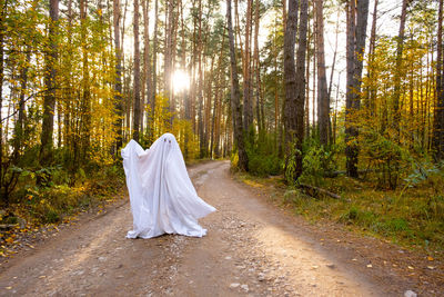 Rear view of woman standing in forest