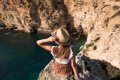 Rear view of woman standing on rock