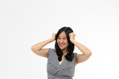 Portrait of smiling young woman against white background