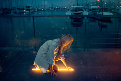 Woman with illuminated leaf in water