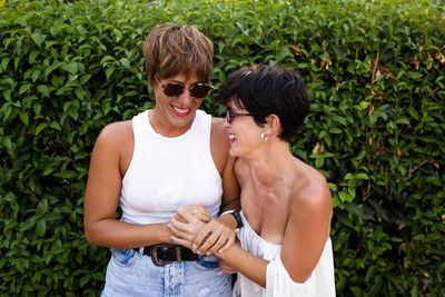 Young man and woman in sunglasses standing outdoors