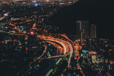 High angle view of city lit up at night