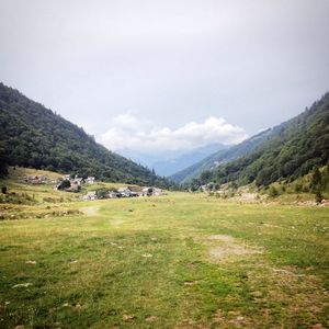 Scenic view of green landscape and mountains against sky