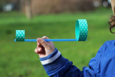 Midsection of girl holding toy on field