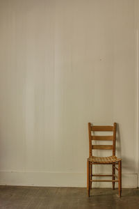 Empty chair against wall at home