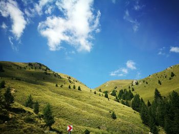 Low angle view of landscape against blue sky