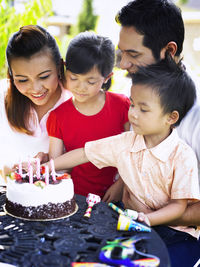 Family celebrating birthday in lawn