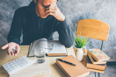 Man having medicine while sitting at table