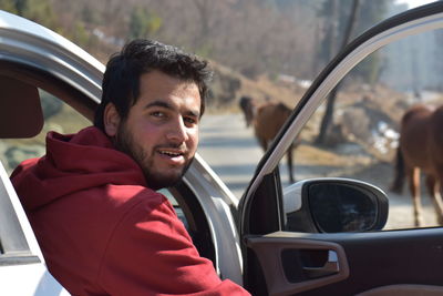 Portrait of young man sitting in car