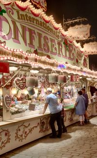 People at illuminated market stall