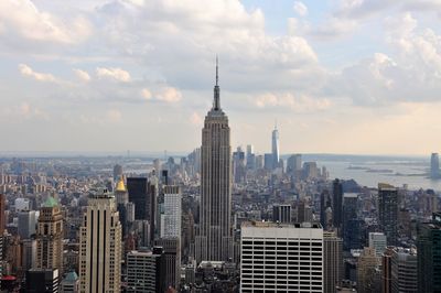 Modern buildings in city against cloudy sky