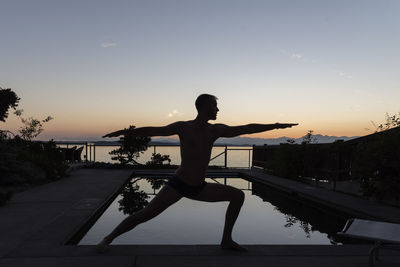 Man doing yoga during sunset