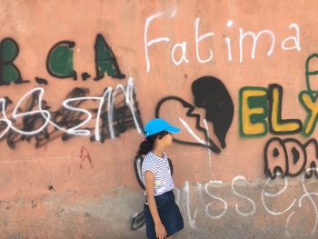Woman standing on graffiti wall