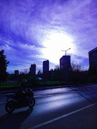 City street and buildings against sky at dusk