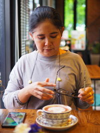 Portrait of young woman holding coffee at home