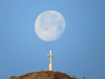 Low angle view of moon against clear blue sky