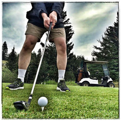 Low section of man standing on golf course