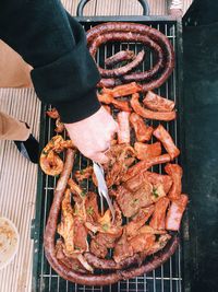 Low section of man cooking meat on barbecue grill