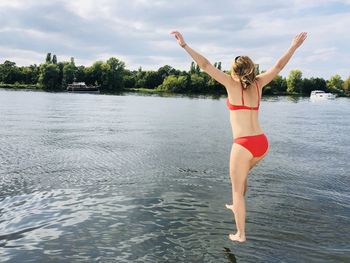 Rear view of woman jumping in lake