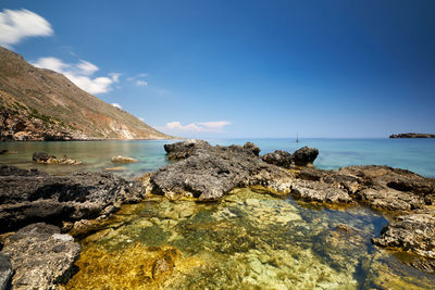 Rocks on beach against sky