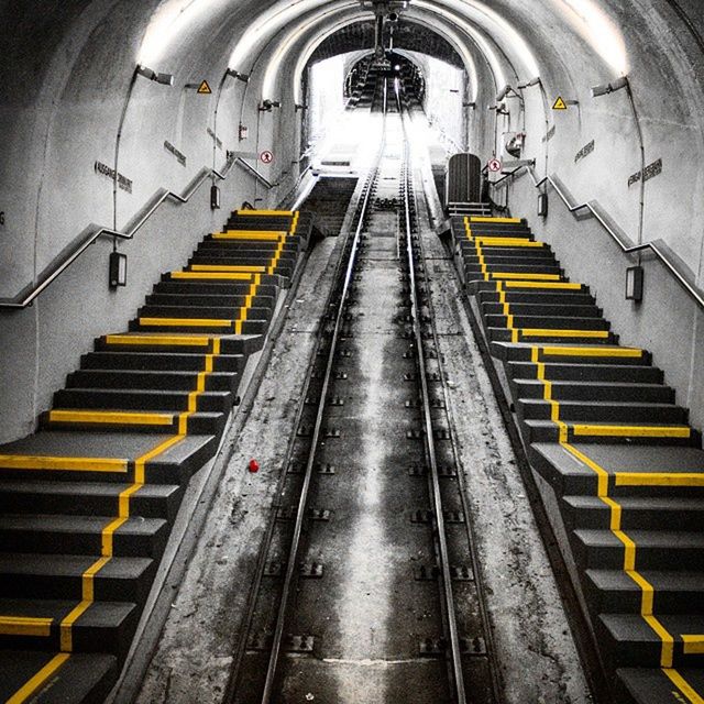 indoors, steps and staircases, steps, staircase, the way forward, architecture, illuminated, built structure, diminishing perspective, escalator, vanishing point, rail transportation, high angle view, railroad station, railing, railroad track, in a row, ceiling, public transportation, transportation