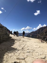 People walking on beach against sky