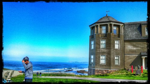 People in front of built structure against blue sky