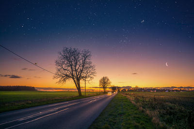 Road amidst landscape against sky during sunset