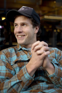 Man with hands clasped looking away while sitting