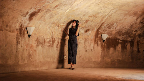 Portrait of woman standing against wall