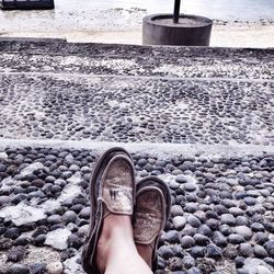 Low section of person standing on pebbles