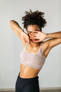 Midsection of woman standing against white background