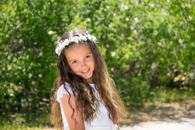 Portrait of smiling girl with long hair wearing flowers