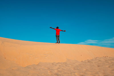 A tourist standing on a sand dune at mambrui sand dunes in malindi, kilifi county, kenya