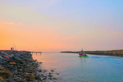 Sailboat on sea against sky during sunset