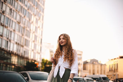 Thoughtful young woman walking on street in city during summer