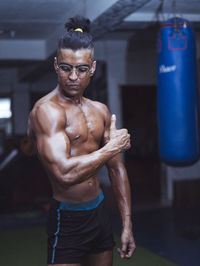 Shirtless man exercising at gym