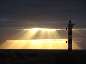 Silhouette lighthouse against sky during sunset