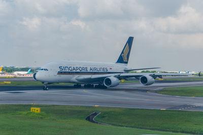 Airplane on runway against sky