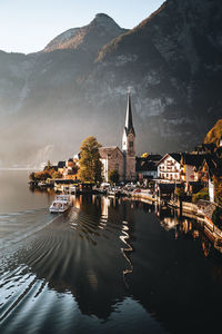 Buildings reflecting on lake against mountain