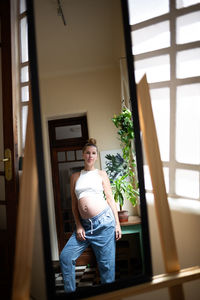 Portrait of young woman looking through window