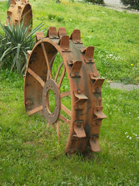 Close-up of rusty wheel on field