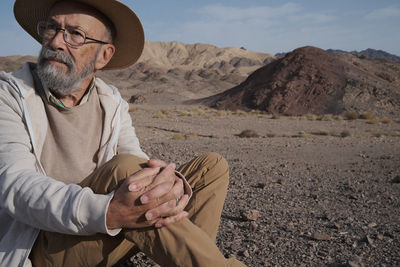 Portrait of senior man sitting at desert
