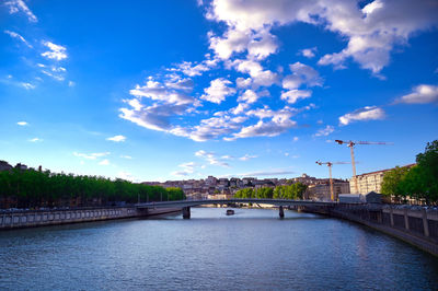 Bridge over river against sky in city